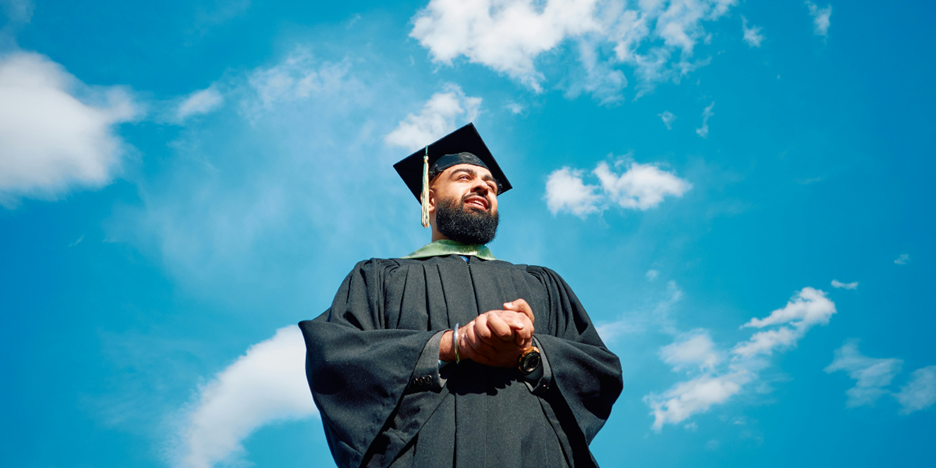 Bearded man in graduation cap and gown.