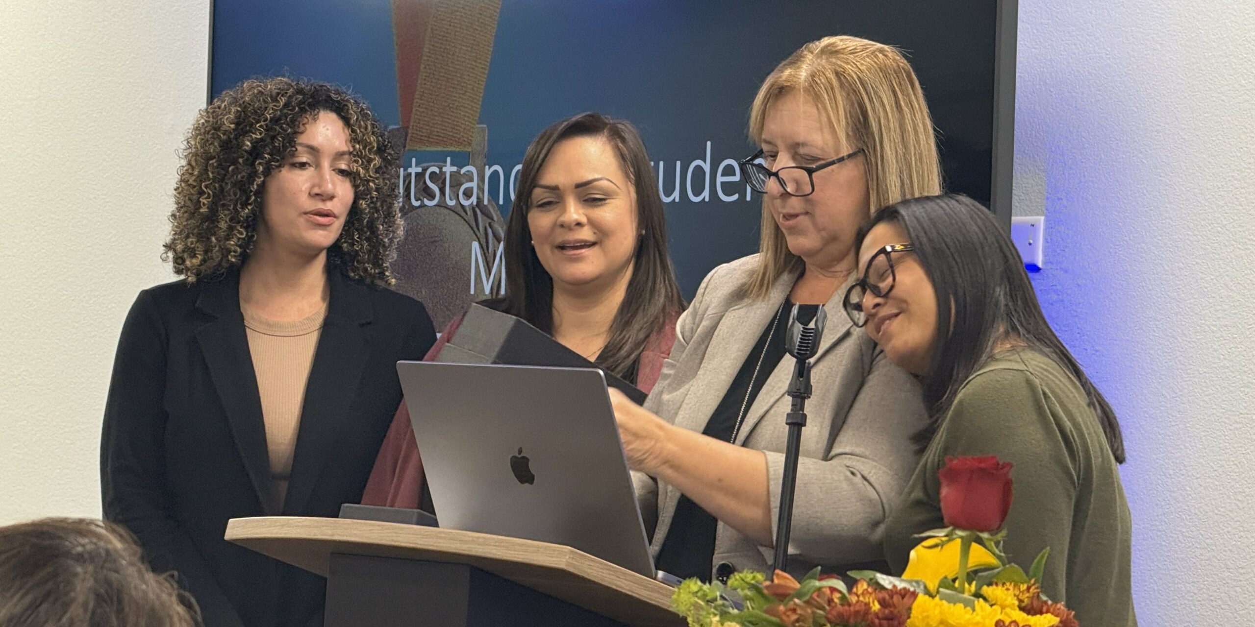 Four women standing at a podium